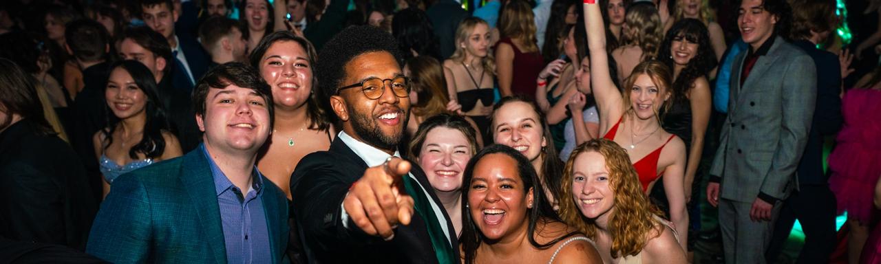 Students pointing at the camera and smiling at Presidents' Ball